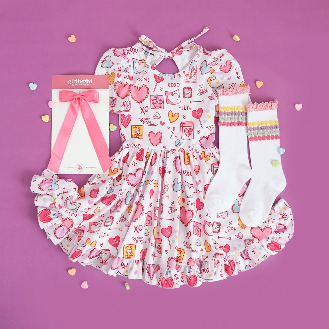 girls class valentine print party dress with matching pastel stripe knee highs and pink satin bow