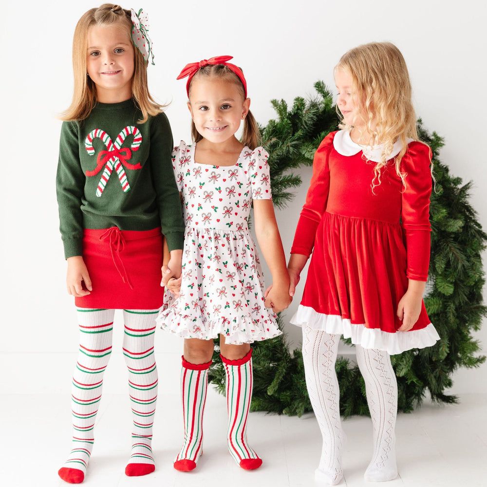 girls wearing classic christmas outfits with candy cane stripes