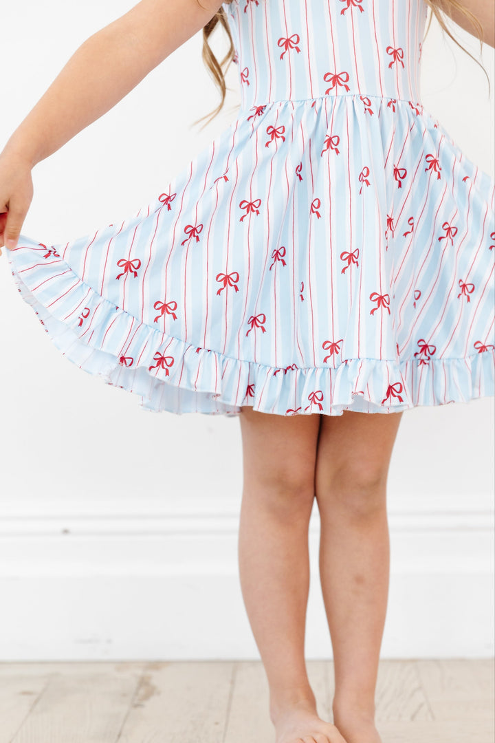 detail picture of girls sleeveless twirl dress with white, blue and red stripe with dainty red bow print for 4th of July