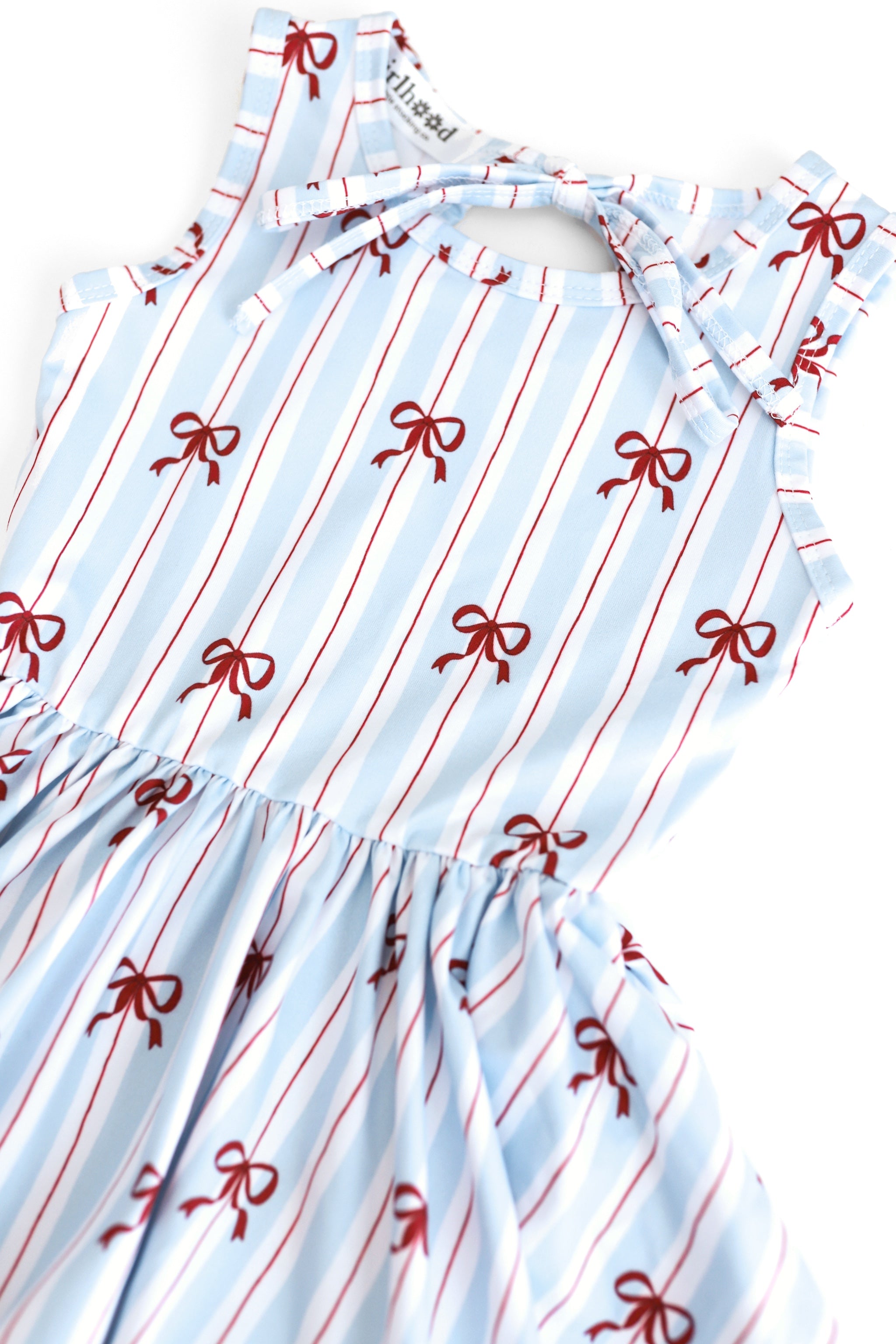 closeup photo of girls sleeveless twirl dress with white, blue and red stripe with dainty red bow print for 4th of July