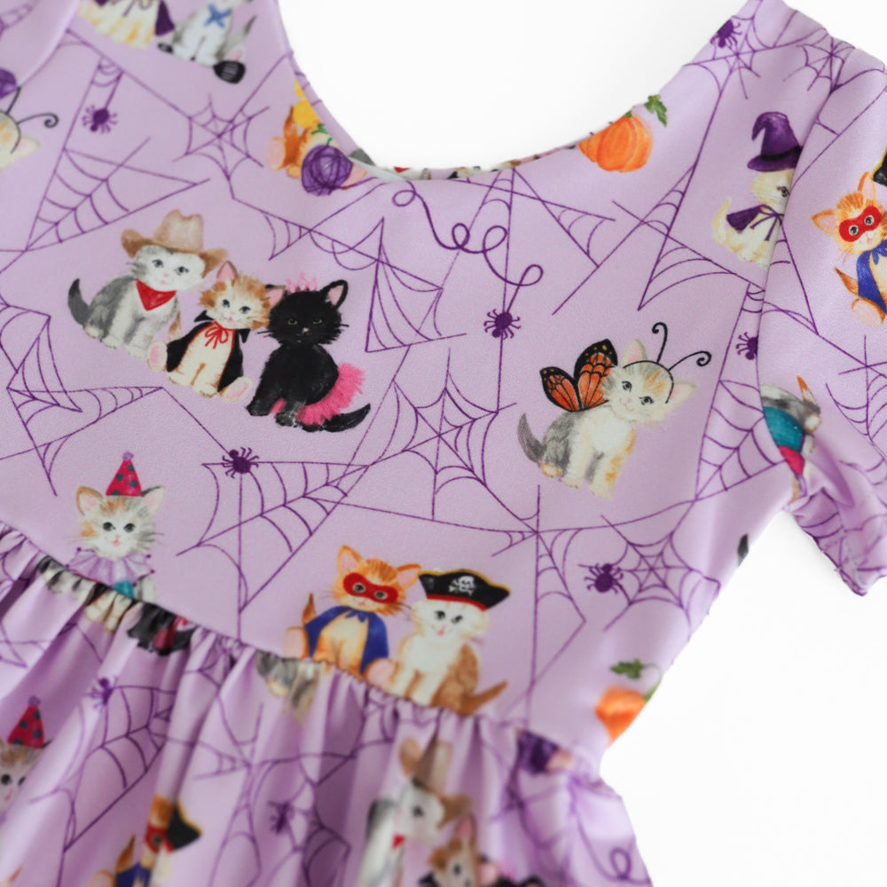 detail photo of lavender dress bodice with purple spider web design and cute kittens dressed up for Halloween