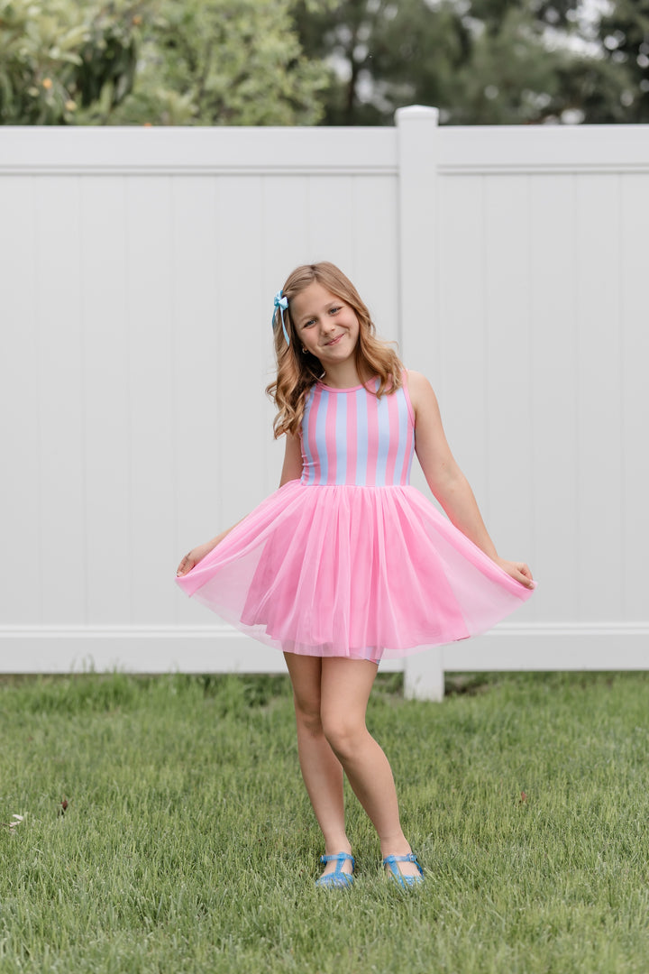 girl wearing pink cotton candy themed set with pink and blue stripes on top and pink tulle tutu and matching shorts