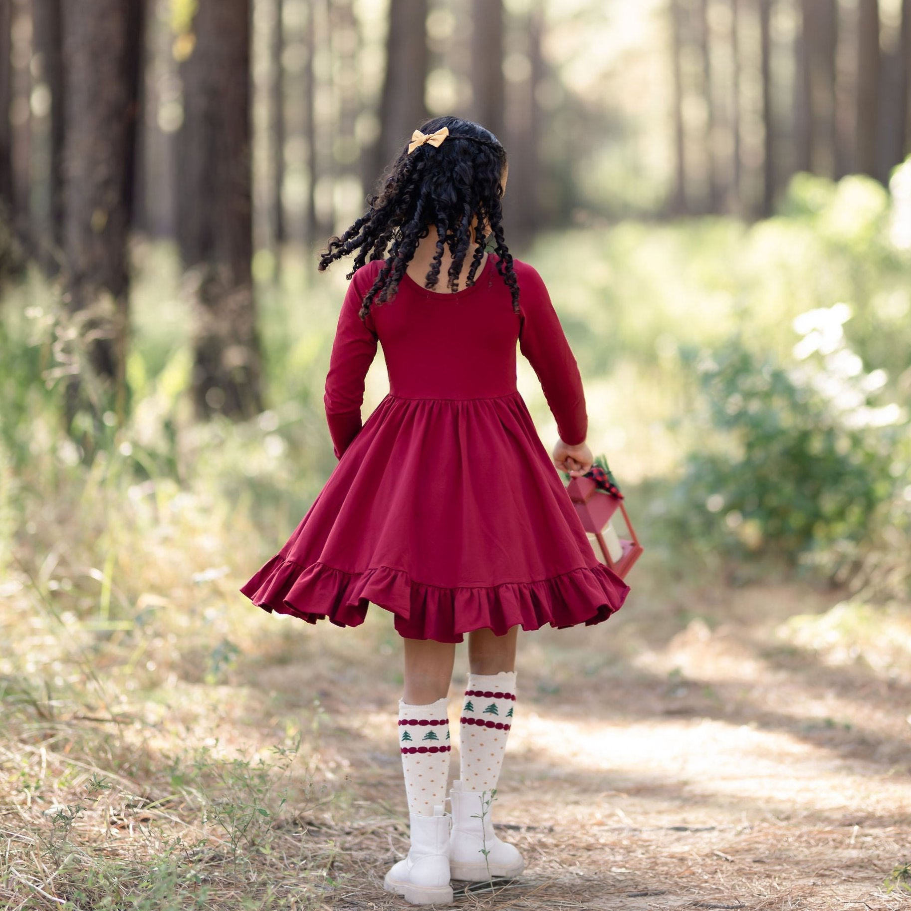 girl wearing crimson red twirl dress in the forest