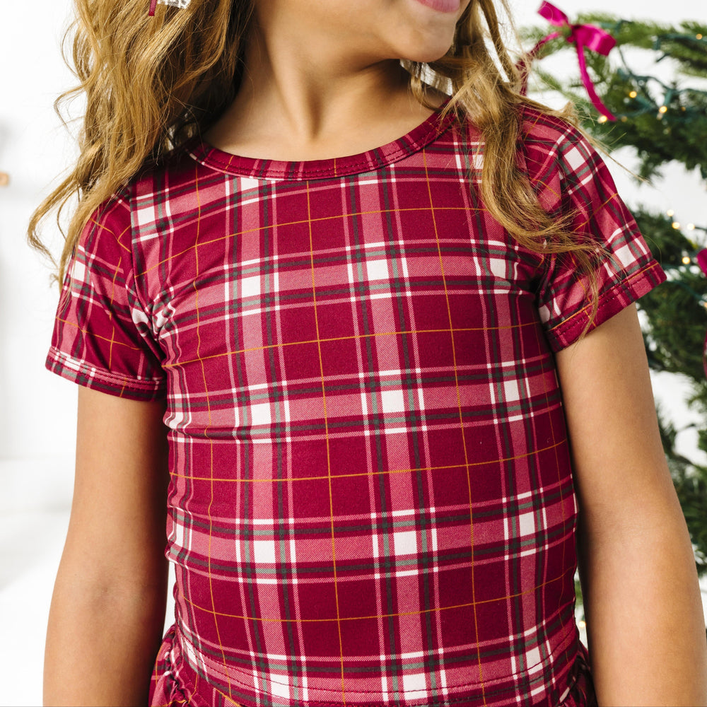 closeup of little girl in crimson plaid short sleeve fitted top 