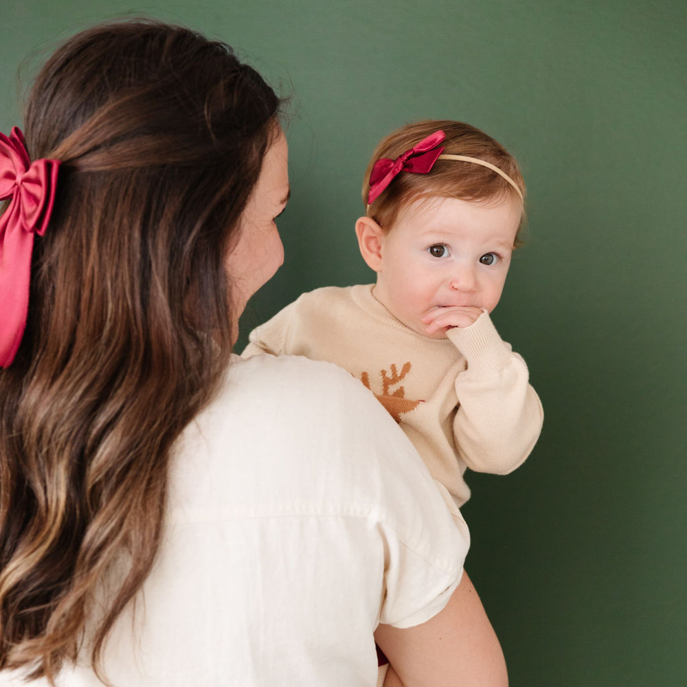 baby and mother in matching red satin hair bows