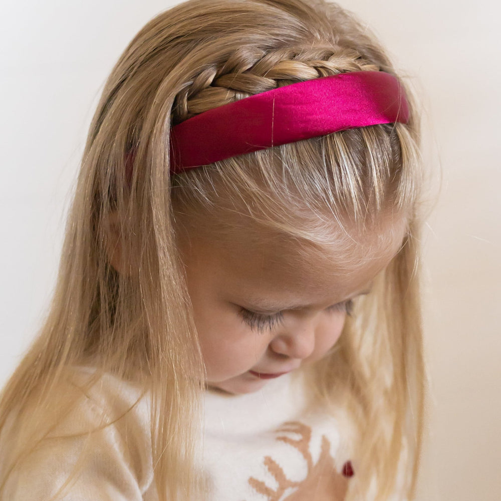 little girl in crimson red satin headband with red nosed reindeer sweater for Christmas 