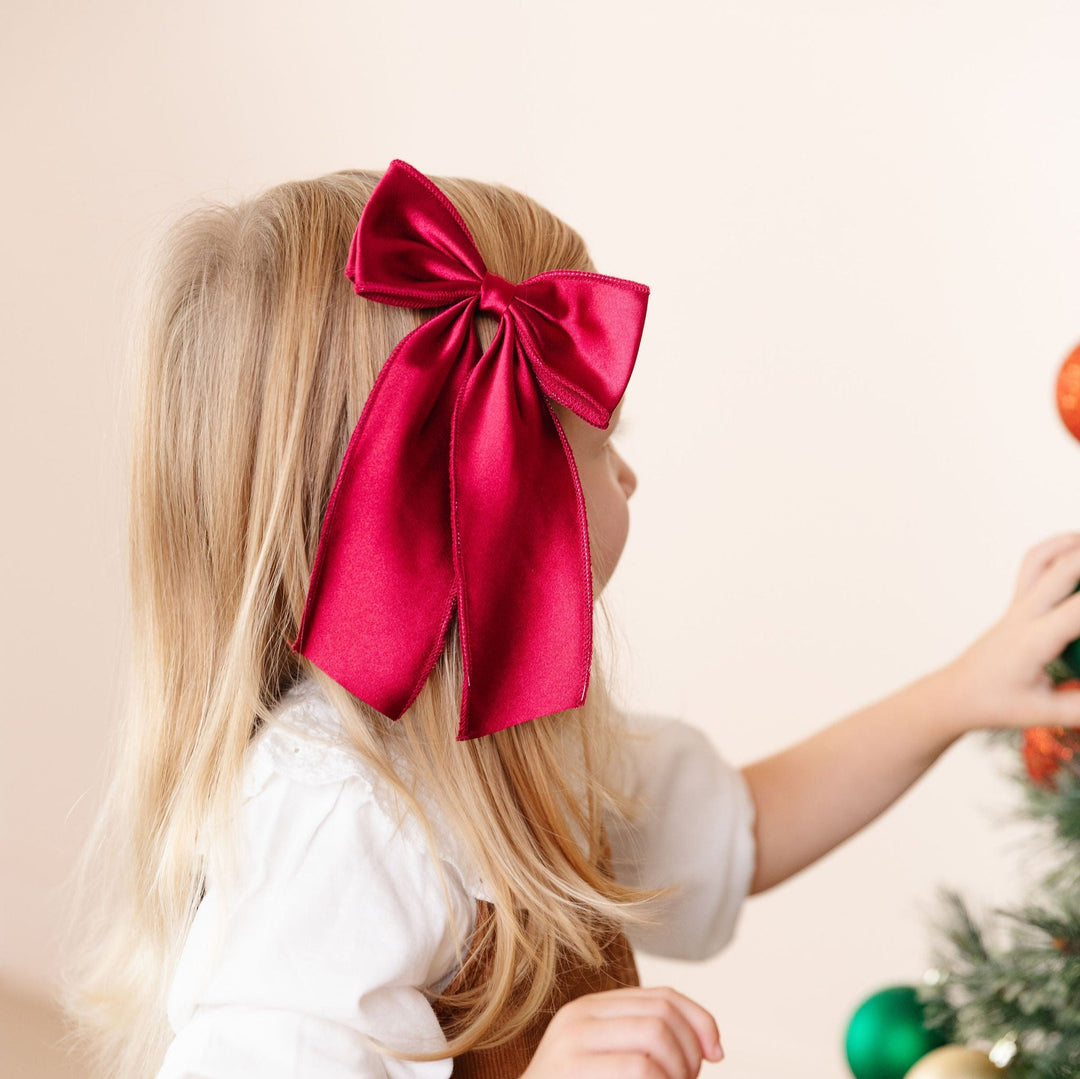 little girl in red satin Christmas hair bow