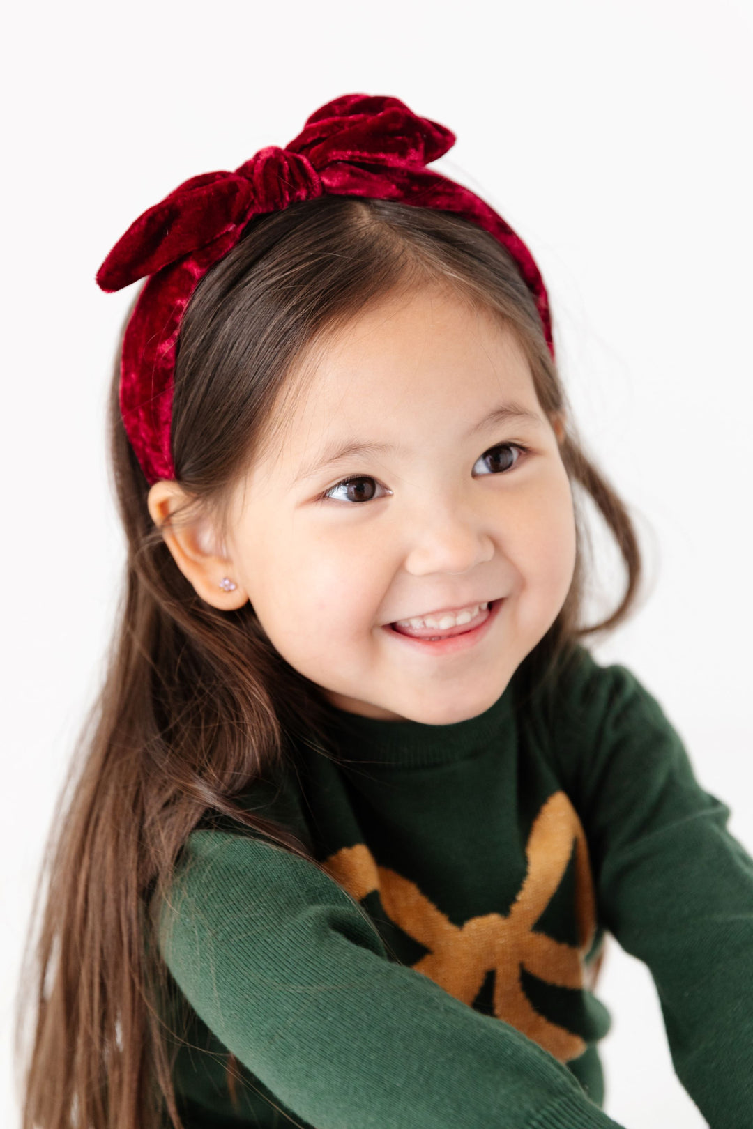 little girl in crimson velvet headband and coordinating forest green sweater set