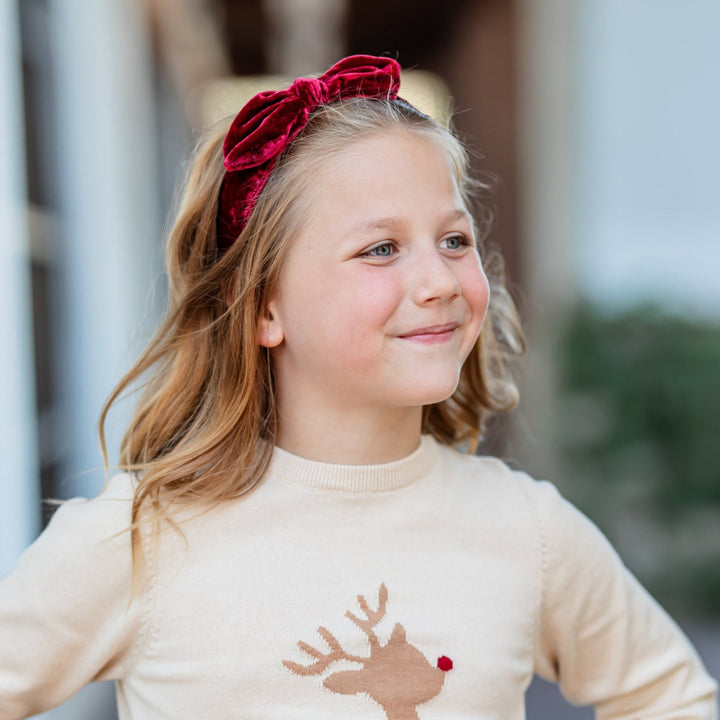 little girl in Rudolph reindeer knit pullover sweater and matching red velvet hair bow 