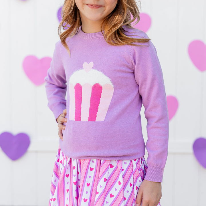 closeup of little girl in lavender cotton knit pullover sweater with pink cupcake design and Valentine's print dress