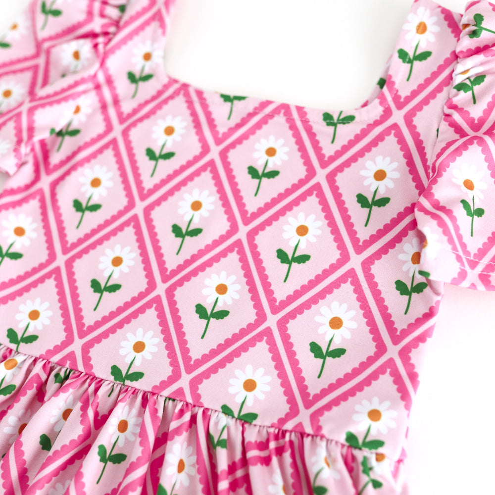 closeup of pink twirl dress bodice with taffy pink scalloped diamond design and white daisies