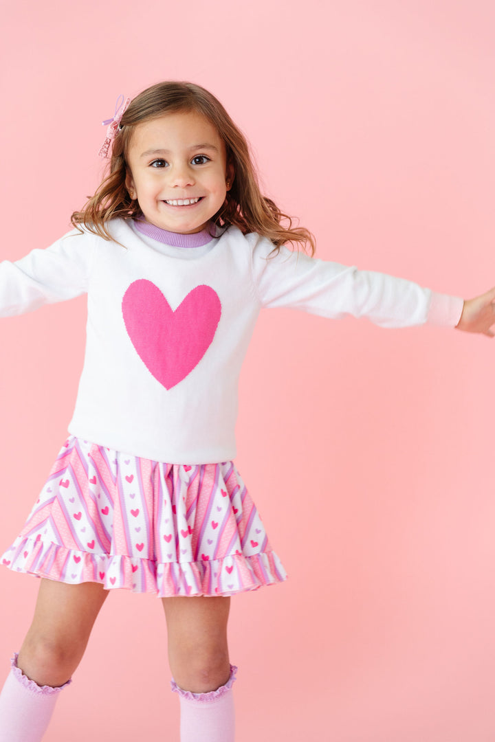 little girl in darling heart wallpaper inspired twirl dress with matching heart sweater and lavender knee highs