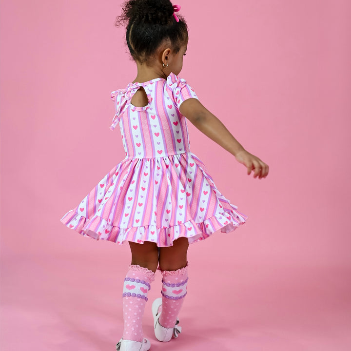 girl twirling in valentine's heart wallpaper dress with tie back and matching knee highs