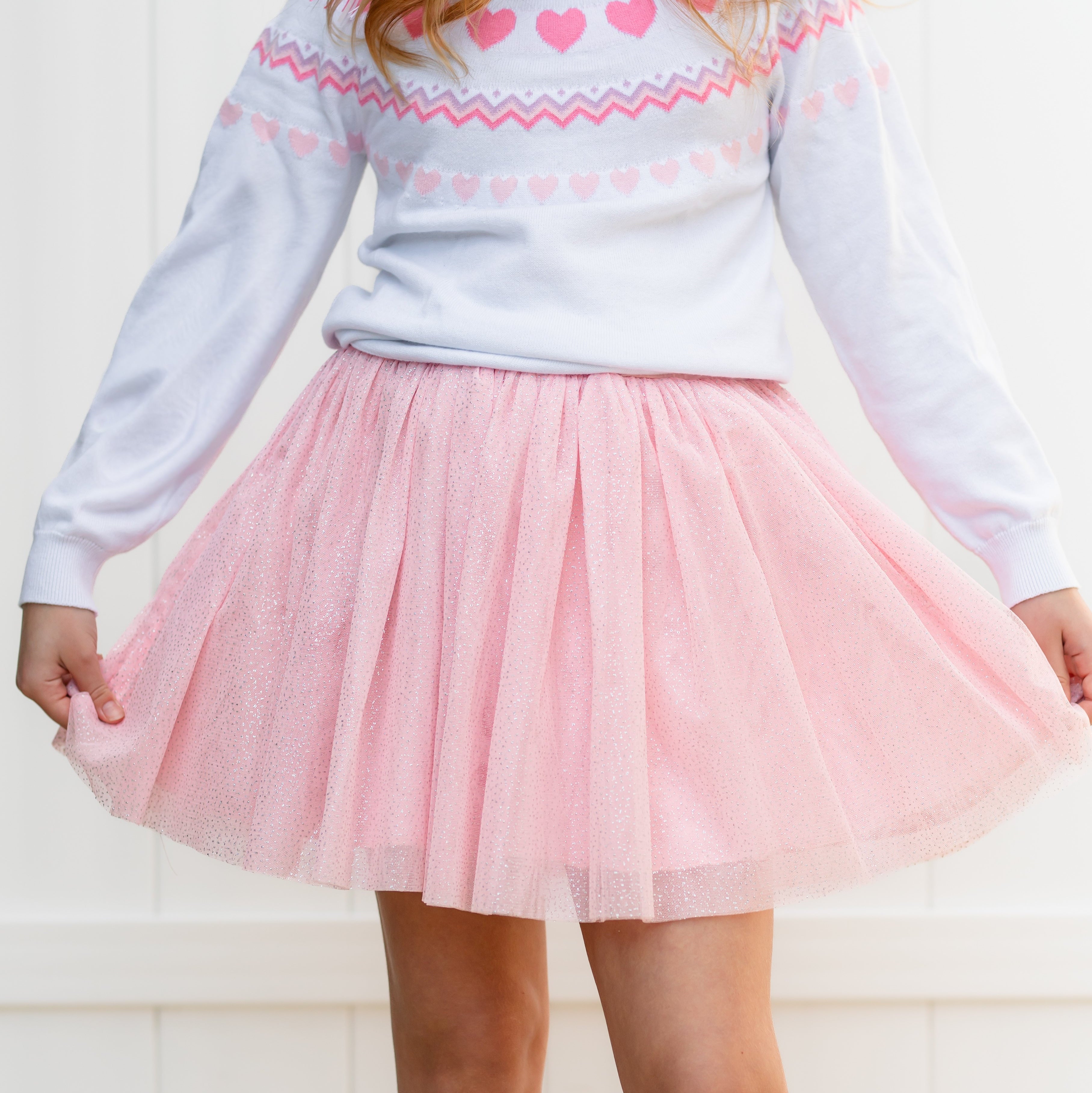 close up of light pink sparkly tulle skirt paired with white fair isle heart sweater for Valentine's Day
