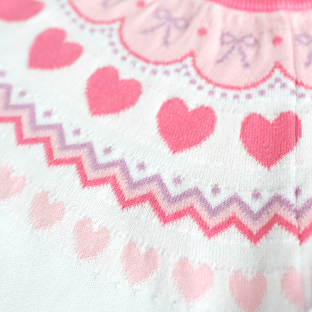closeup of heart and bow themed fair isle print sweater in pastel pinks and lavender for girls valentines day outfits
