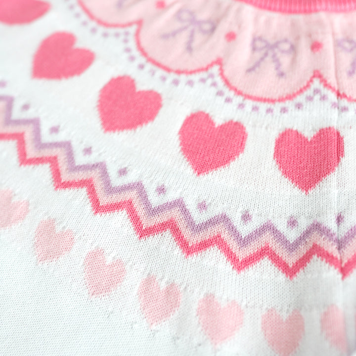 closeup of heart and bow themed fair isle print sweater in pastel pinks and lavender for girls valentines day outfits