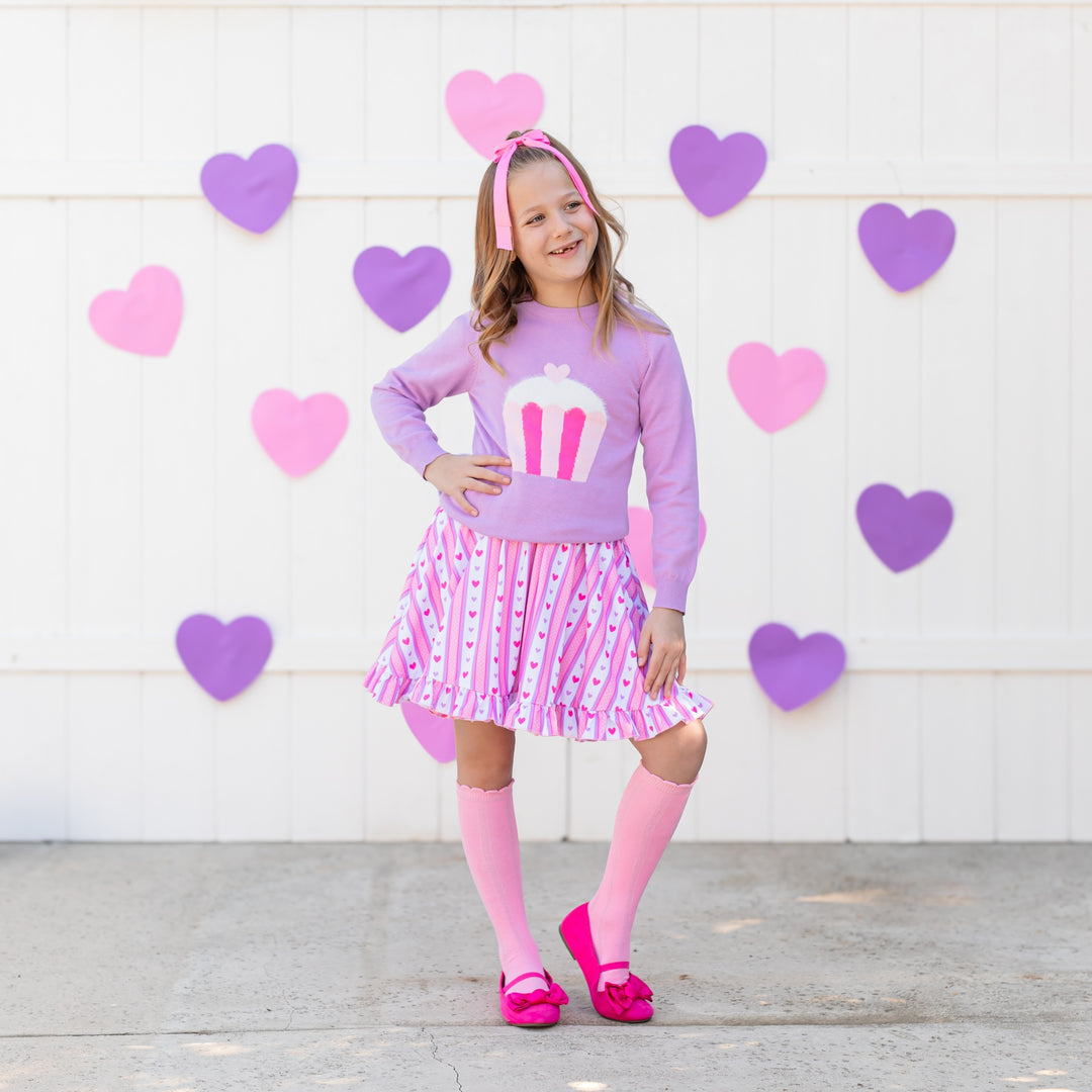 girl in purple sweater and pink cupcake with vintage inspired valentine's wallpaper print and pink knee highs