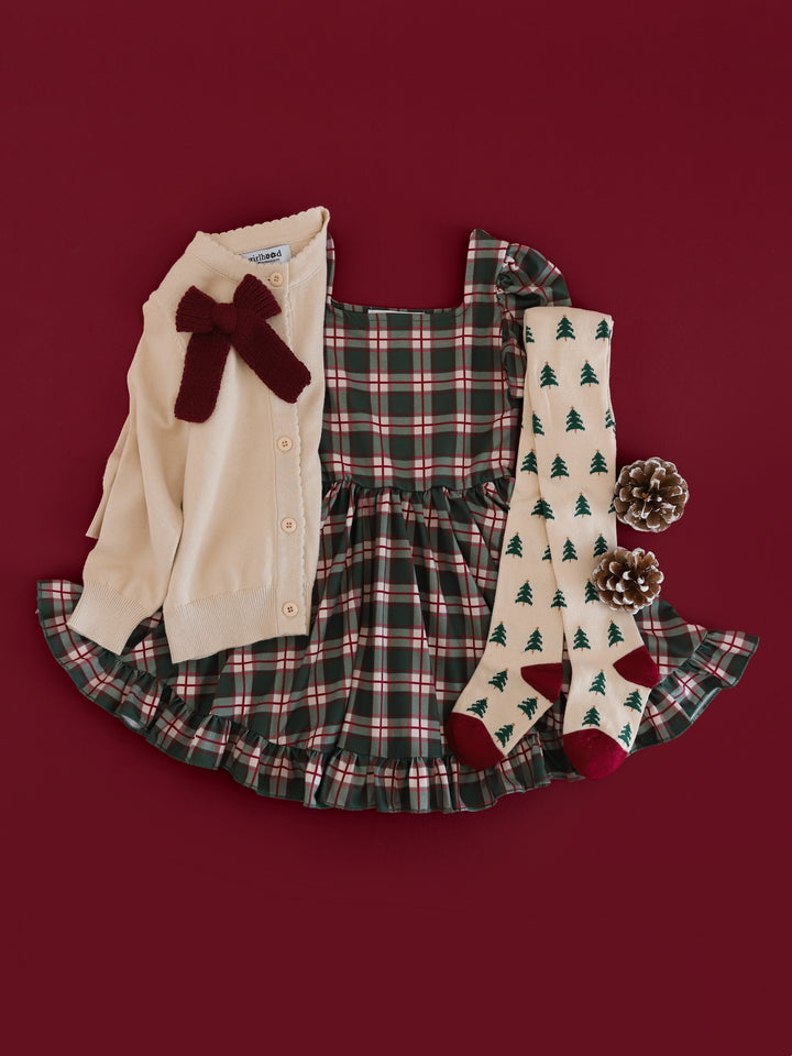girls' forest green plaid short sleeve twirl dress paired with cream cardigan, burgundy knit bow and Christmas tree pattered tights 