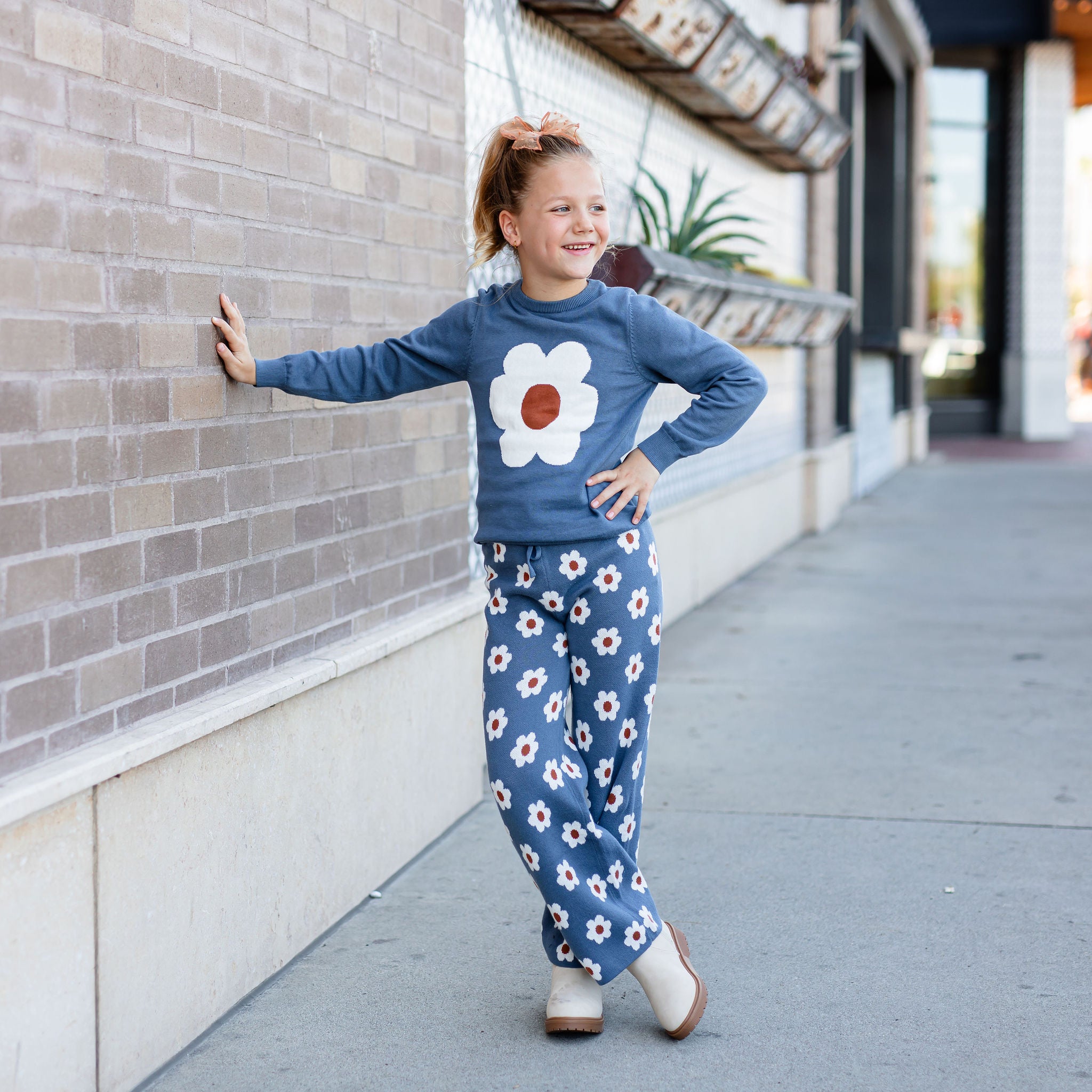 little girl standing outside wearing denim floral sweater set