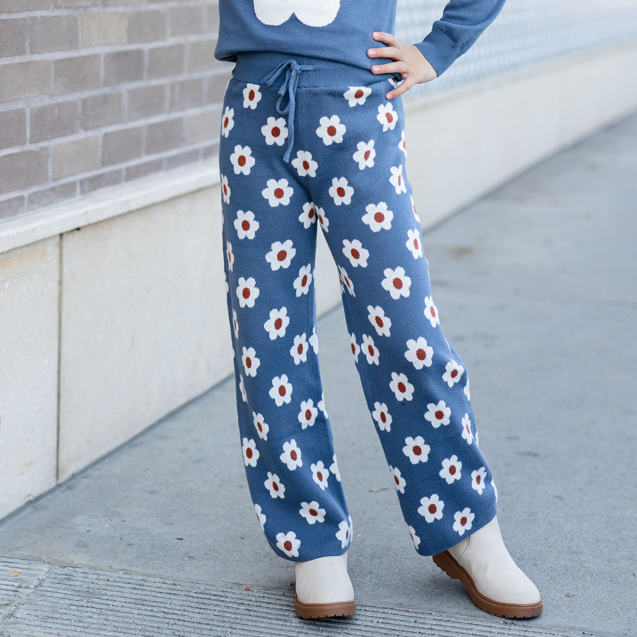 girl wearing denim blue and neutral flower design sweater pants