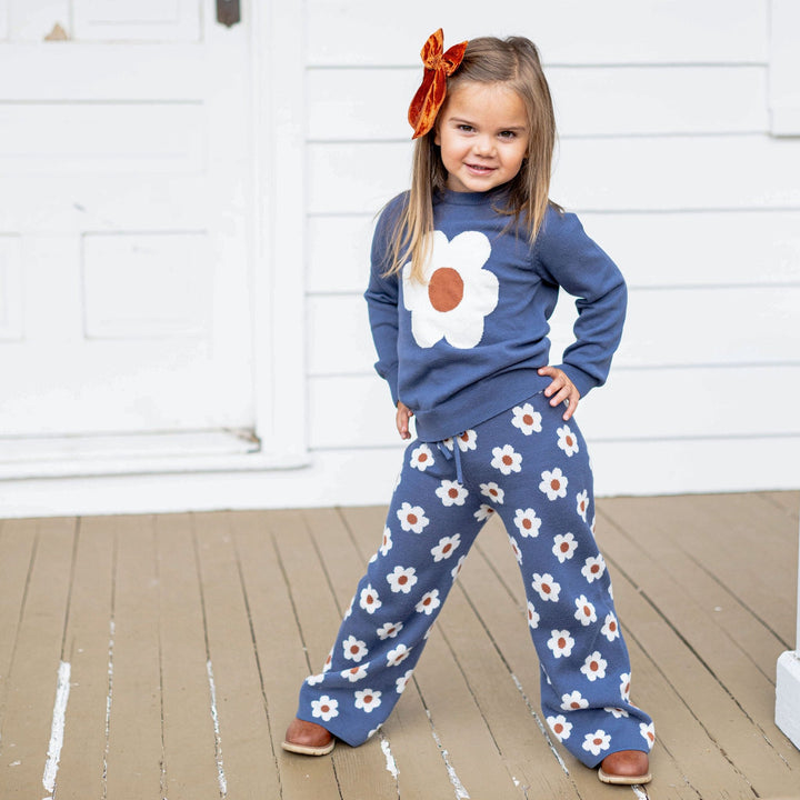 little girl with hands on hips wearing denim and neutral floral sweater set