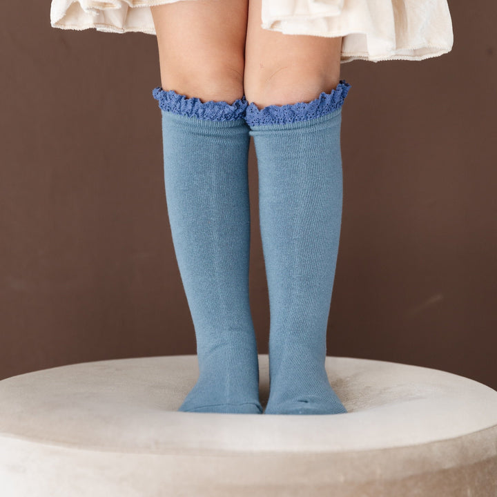 little girl in blue knee high socks with 
 matching crochet lace details