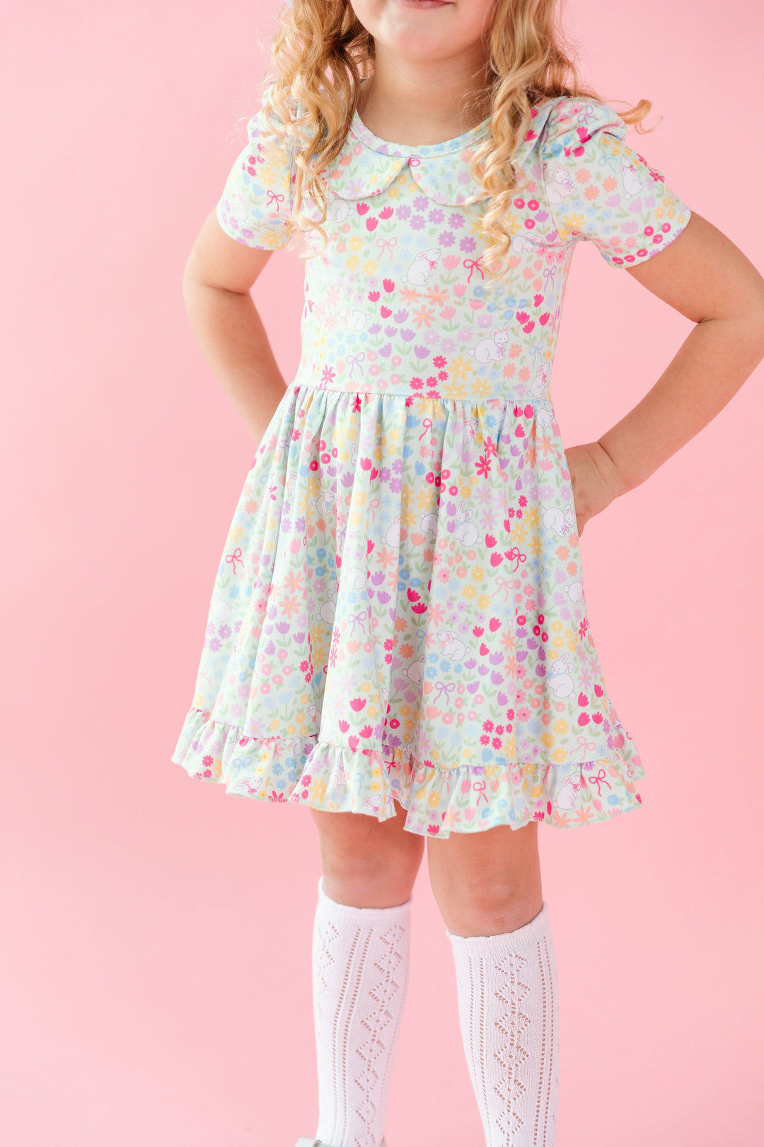 little girl in Easter floral twirl dress and white pointelle knee high socks