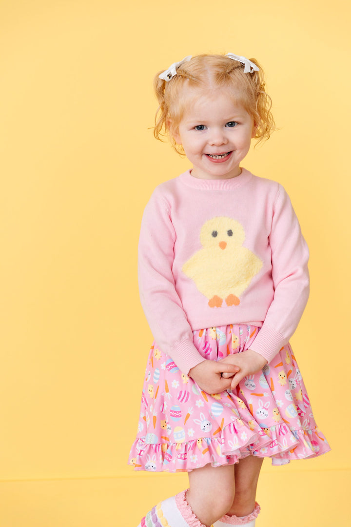 little girl in pink pullover sweater with yellow chick design and Easter print twirl dress with matching socks and bows