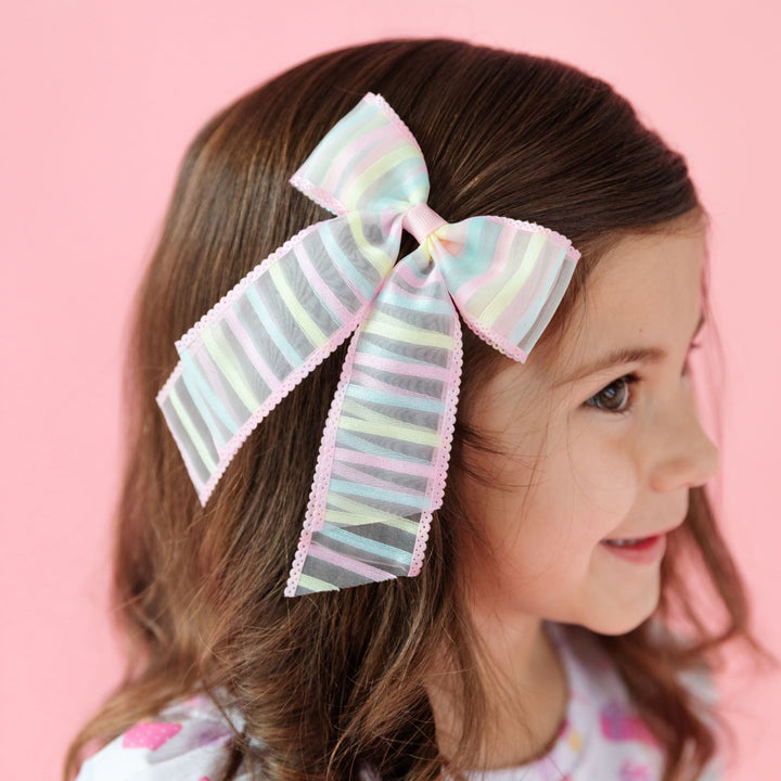 little girl in sheer pastel striped hairbow with pink trim for birthday outfit and easter