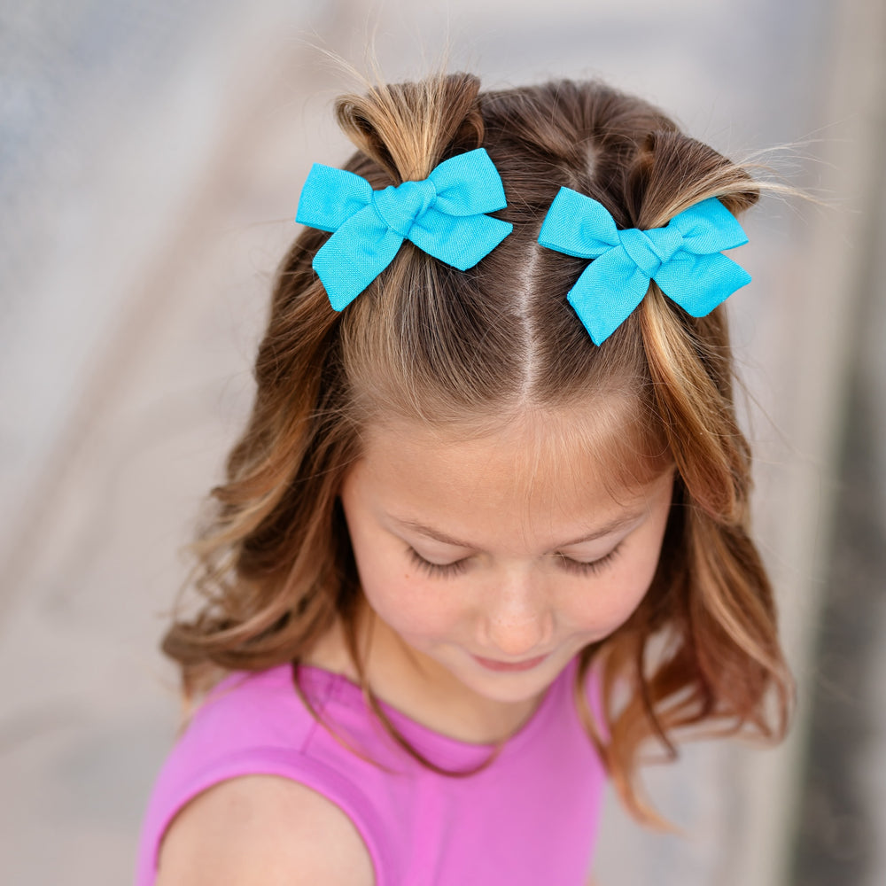 little girl wearing electric blue pigtail bows