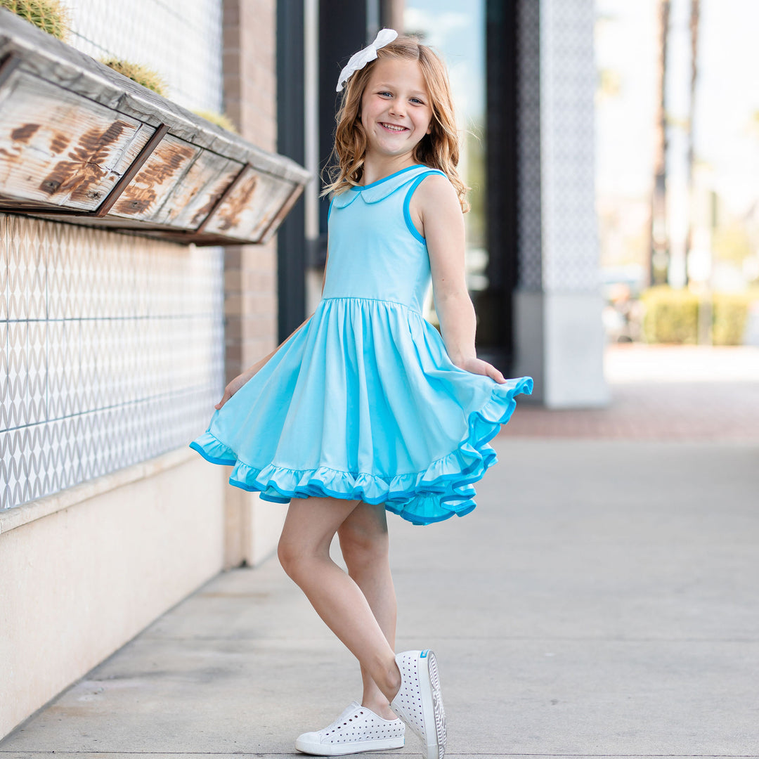 little girl wearing bright aqua blue summer dress holding out full circle twirl skirt