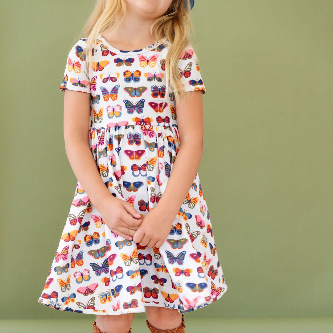 little girl wearing butterfly print everyday pocket dress 