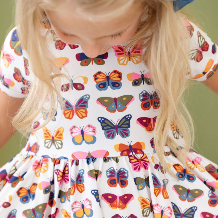 little girl wearing fall toned butterfly print dress