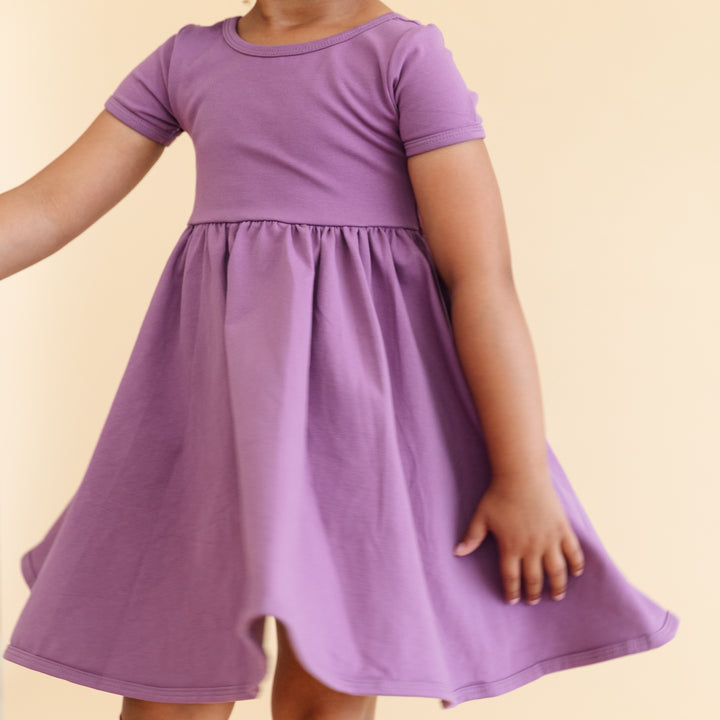 close detail of purple cotton everyday dress on little girl