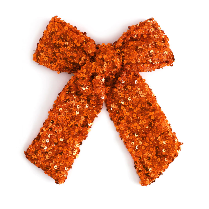 girl's sequin covered orange bow on clip for fall and Halloween