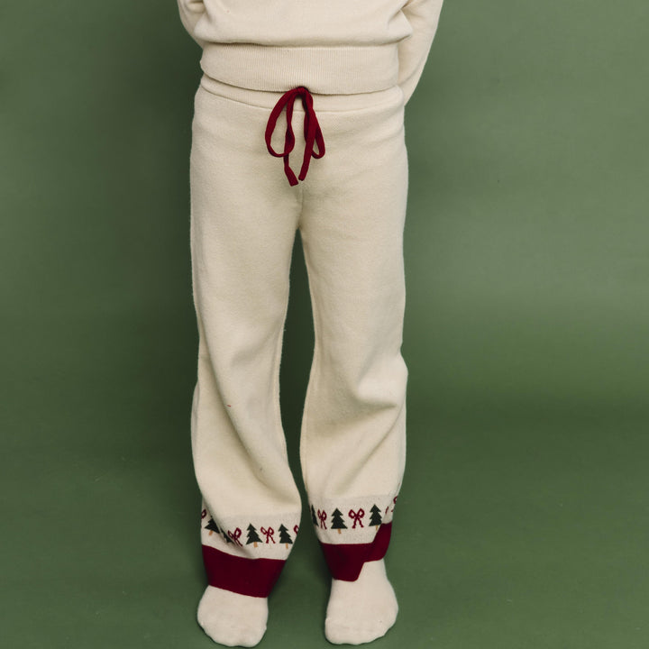 child in cream knit sweater pants with fair isle payyern at the ankle to match pullover sweater