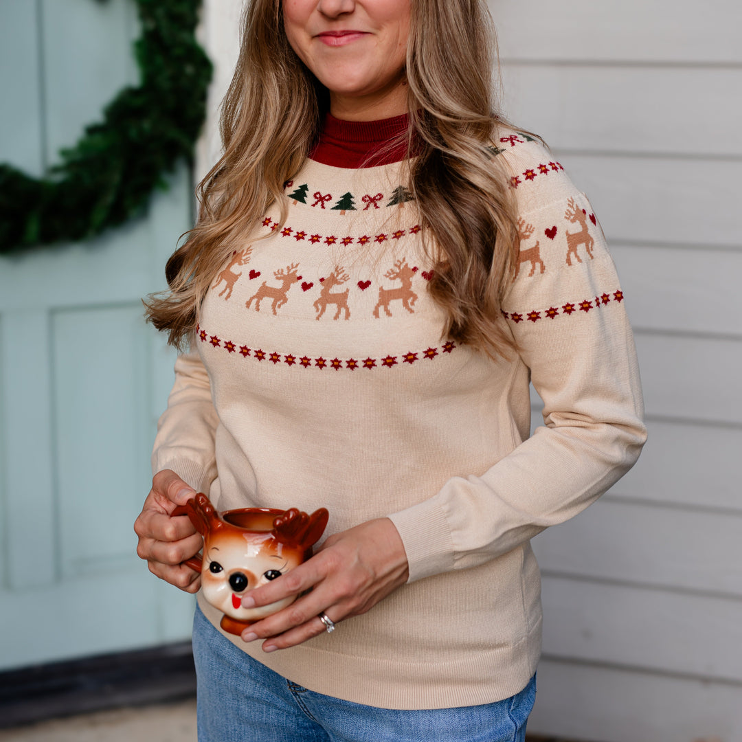 woman in cream knit pullover sweater with fair isle reindeer print for Chrismtas