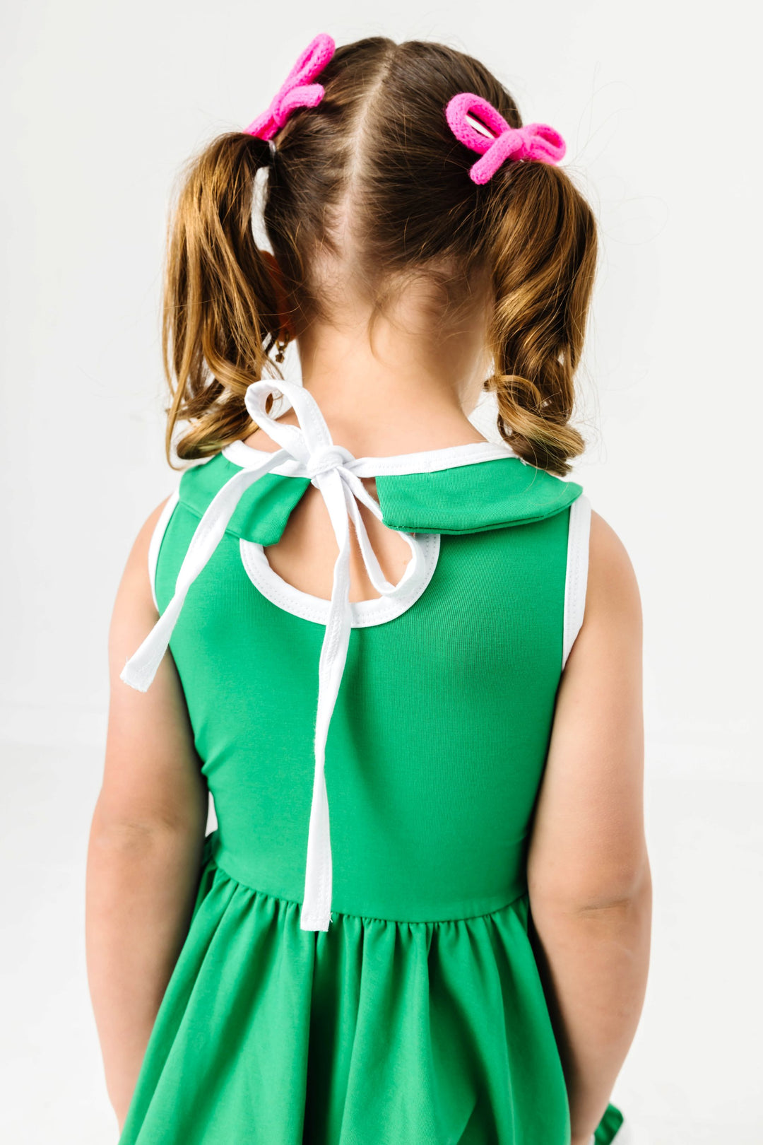 close up of tie back on little girl's green collared twirl dress with white trim