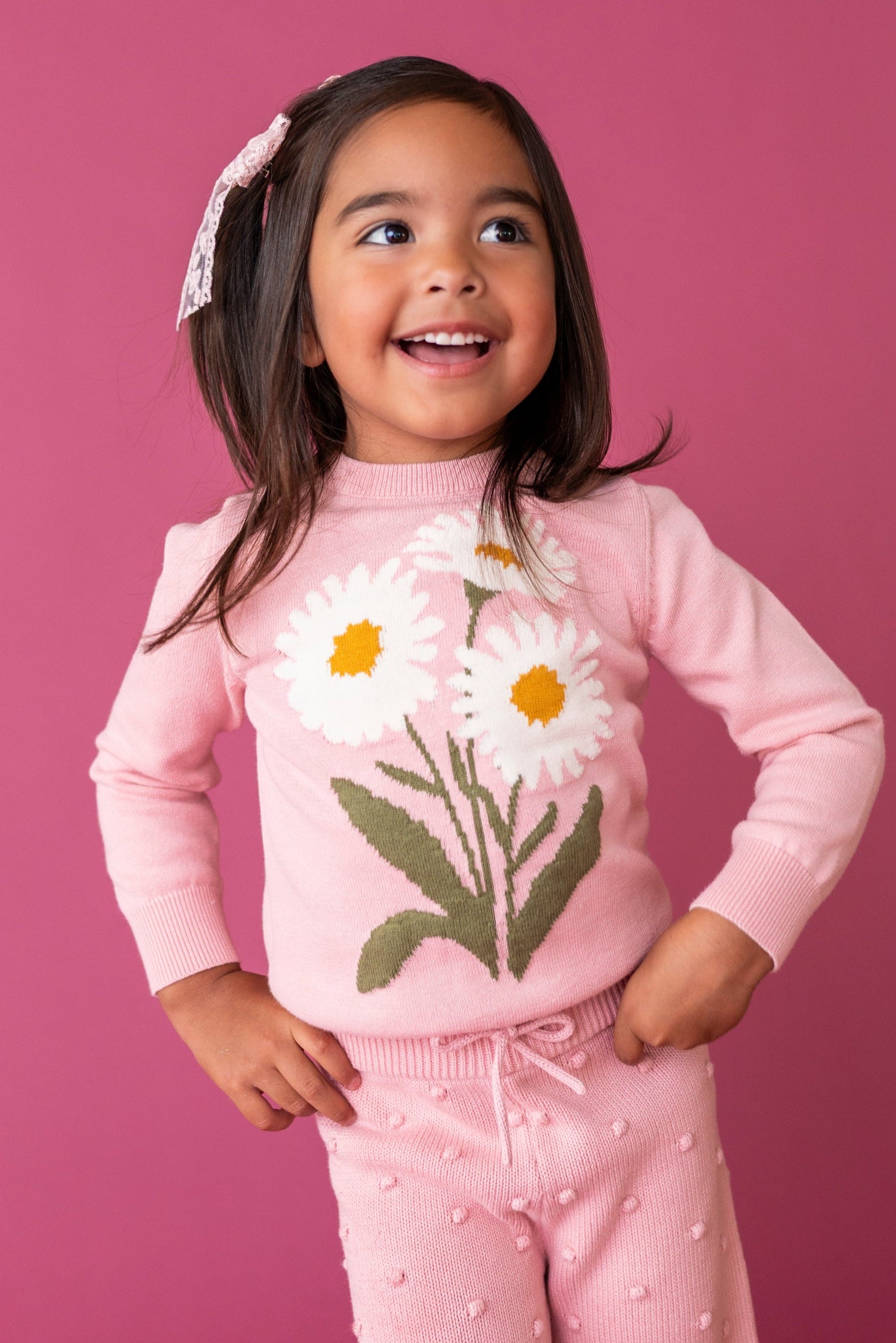 young girl in light pink sweater with white daisy design and 3D raised bubble design pants for fall