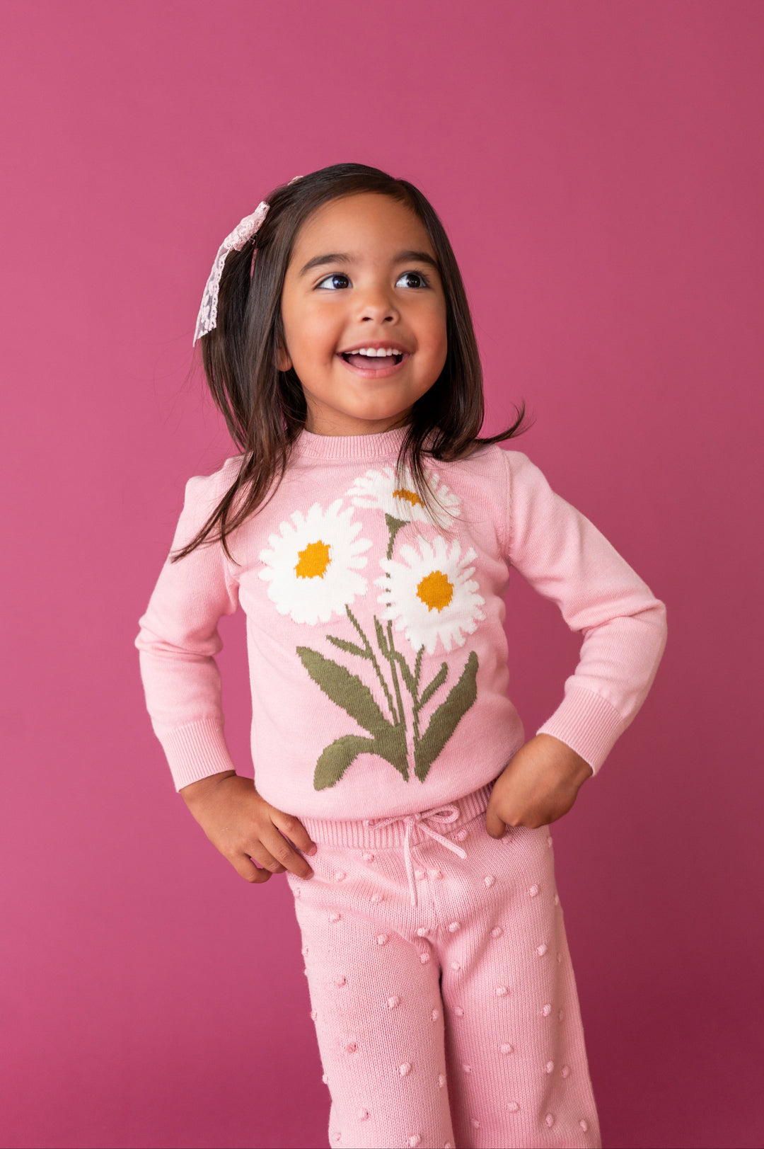 young girl in light pink sweater with white daisy design and 3D raised bubble design pants for fall