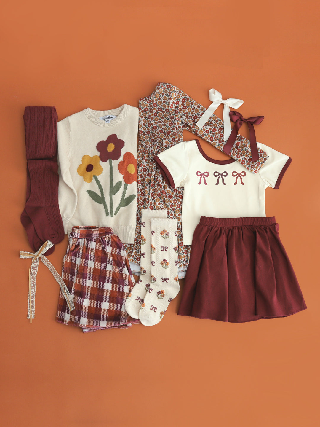 girls' fall flat lay pairings with fall floral sweater, velvet dress, and mix and match fall separates and accesories for fall family photos