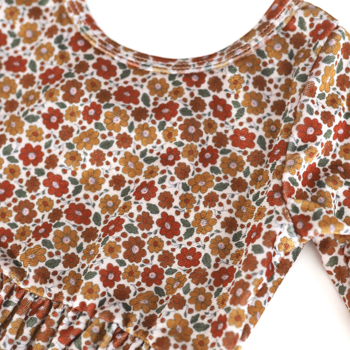 close-up of girl's floral velvet dress print in fall colors