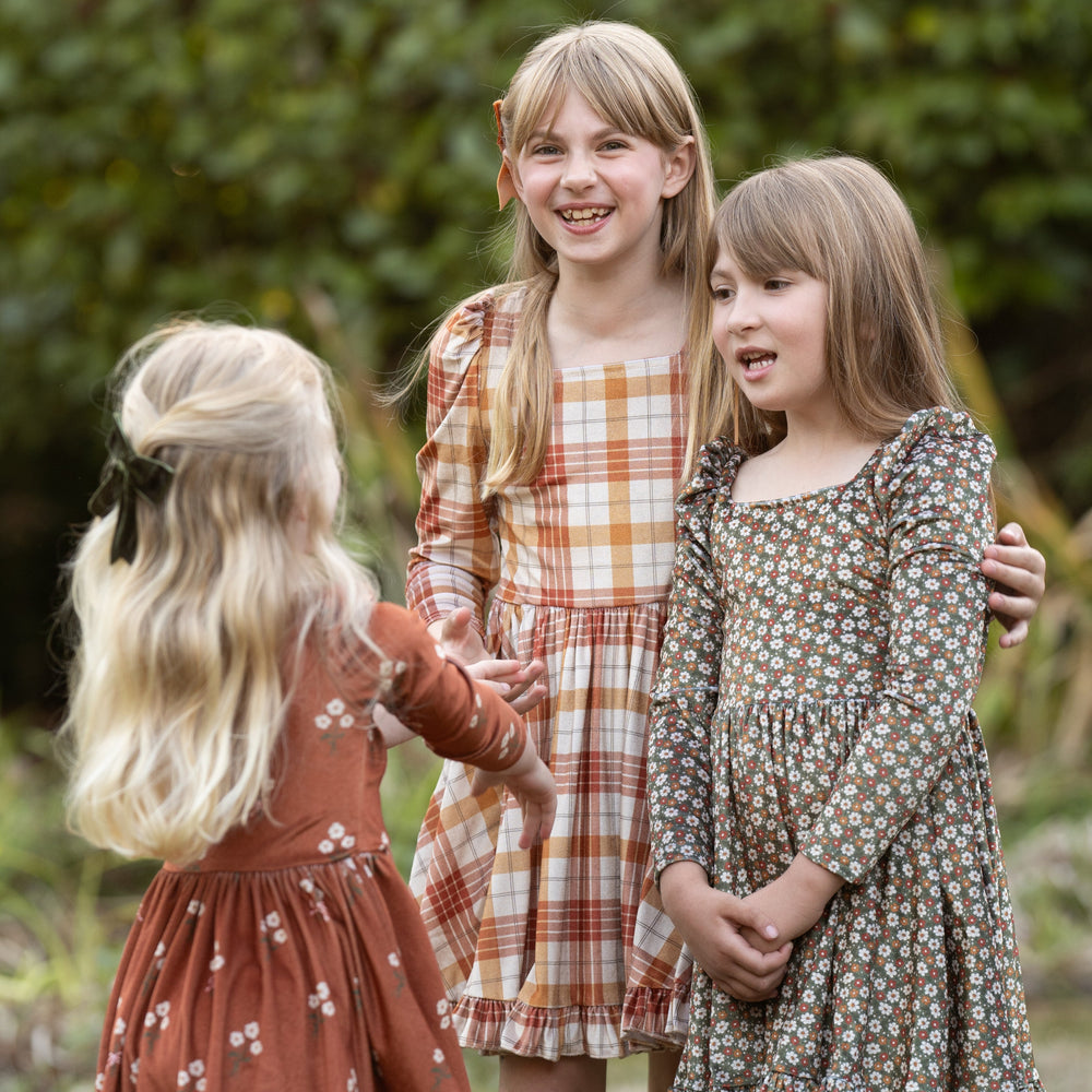 girls in coordinating long sleeve fall floral and plaid velvet dresses for family photos