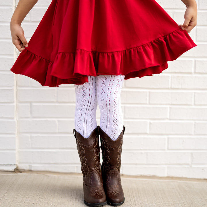 little girl in valentines red twirl dress and fancy white crochet tights and cowgirl boots