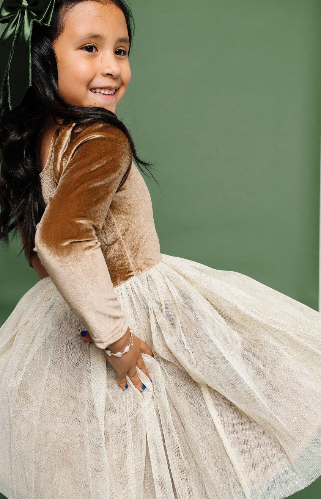 little girl twirling in golden brown and cream velvet tutu party dress for Christmas