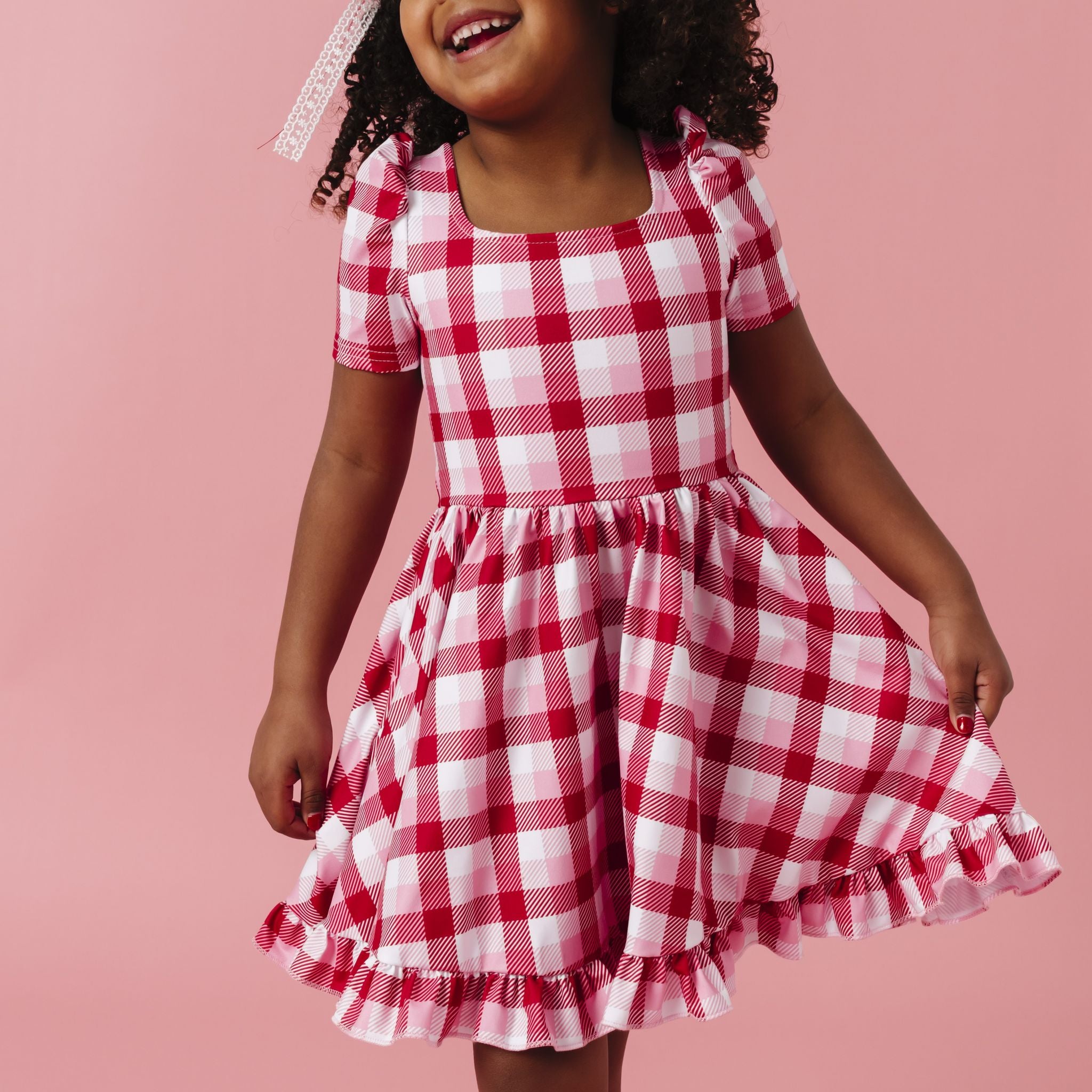 young girl in red, white and pink plaid square neck, short sleeved twirl dress for valentine's day