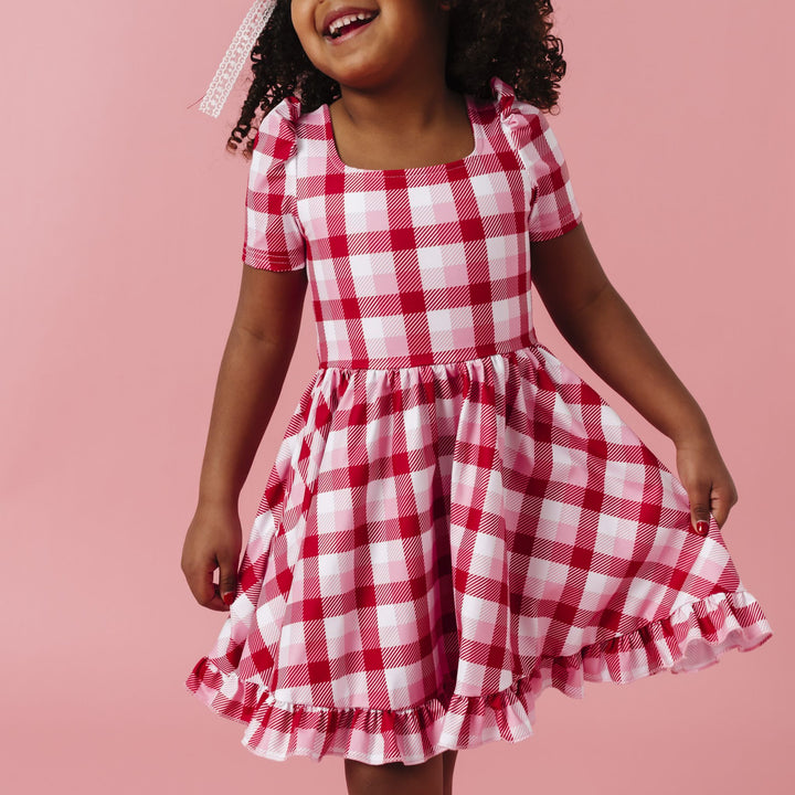 young girl in red, white and pink plaid square neck, short sleeved twirl dress for valentine's day