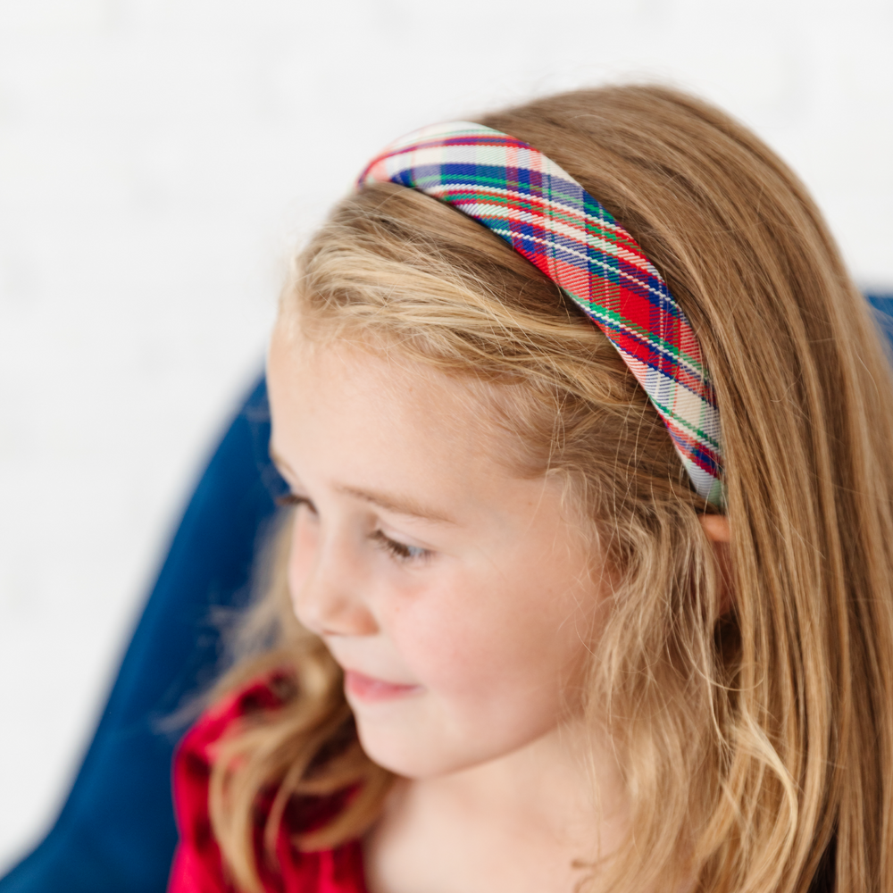 little girl in classic red, blue and green Christmas headband