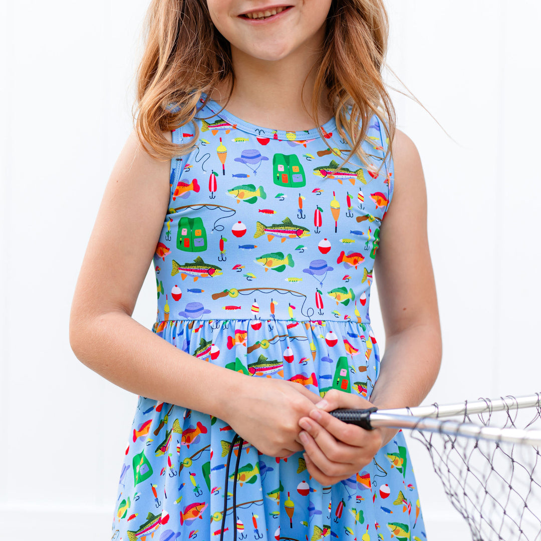 fishing print dress detail on little girl holding fishing net