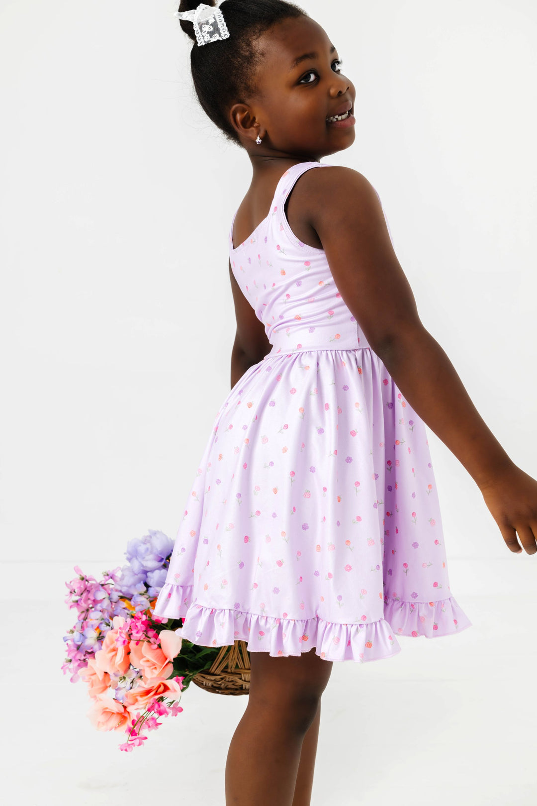 girl holding flower basket in light lavender twirl dress with pastel rosette print